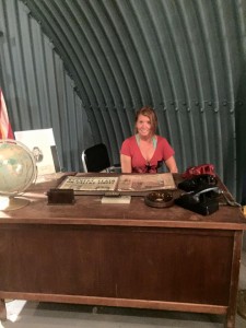 Kim seated at JFK's Bomb Shelter Desk